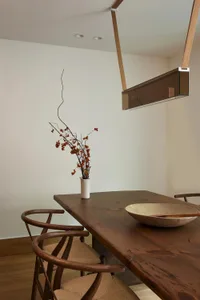 Modern dining room featuring wooden table and chairs.