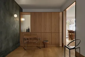 A modern residential interior with wooden elements, minimalist design, and a combination of natural and artificial lighting.