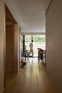 A modern hallway with wooden flooring and minimalist design elements.