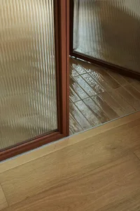A modern bathroom interior featuring glass tiles on the walls and floor.