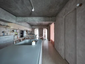 Contemporary kitchen area with concrete countertops and minimalist design.