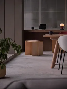 A modern home office space featuring minimalist design with wooden furniture and a laptop on a desk.