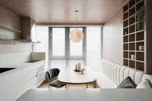 A modern kitchen and dining area with minimalist design elements and a sleek, white color palette.