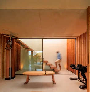 Modern industrial-style fitness studio with wooden elements and exercise equipment.