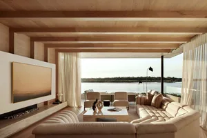 A modern living room featuring a textured sofa with large windows overlooking a scenic view.