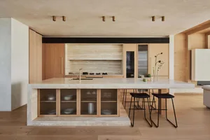 A modern residential kitchen with marble countertops and wooden cabinets