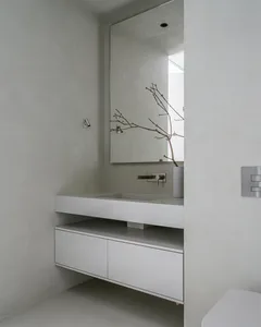 Modern minimalist bathroom with concrete sink and cabinets.