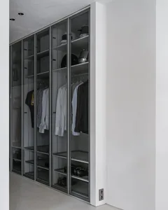 Modern closet with glass sliding doors, shelves, and hanging clothes