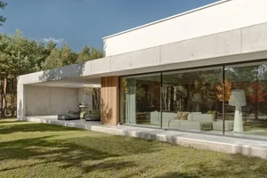Modern concrete residential home with large glass windows and a minimalist design.