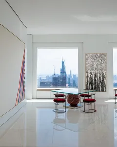 A modern living room featuring marble finishes and a panoramic city view.