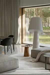 Modern living room featuring a cozy sofa, window with blinds, and natural light streaming in.