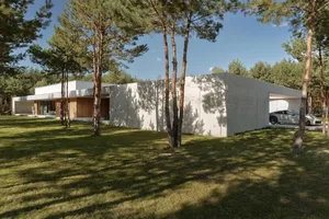 A minimalist house with a modern design featuring concrete walls and a large open space.