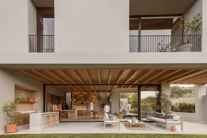 Modern minimalist living room with concrete walls and floor, natural light, and sleek furniture.