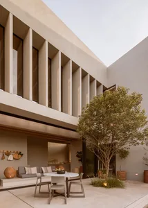 A modern residential building with a concrete facade and outdoor seating area.