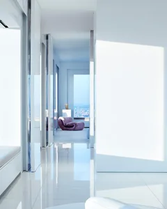 A modern living room with glass windows and white interiors, featuring a purple armchair.