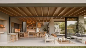 A modern residential living space featuring wooden walls, floors, and furniture, with an open-concept design that blends indo