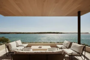 Modern patio with white seating and Scallop Edge design overlooking water.