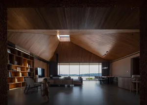 A modern living room with a high wooden ceiling, large windows, and a cozy seating area.