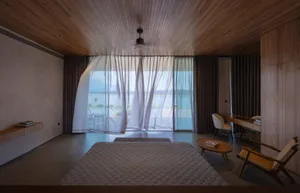 Modern minimalist bedroom featuring wooden furniture and ceiling with a serene view.