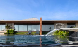 A modern residential exterior featuring a sleek, contemporary design with a mix of concrete and glass materials, set against 