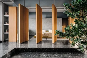 Modern bedroom featuring terrazzo flooring and concrete walls.