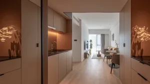 Modern minimalist residential kitchen with terrazzo countertops and warm lighting, showcasing contemporary design features.