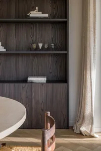 A modern interior with a bookshelf adorned with decorative items such as statuettes and books.