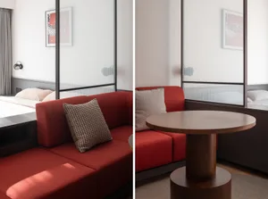 A modern interior with a red couch, pillows, and a wooden table.