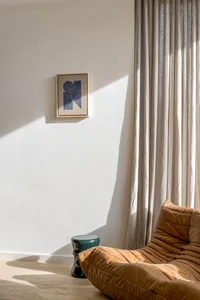 Contemporary living room with a comfortable leather couch and fabric curtains, featuring modern furniture and cozy ambiance.