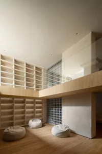 Modern living room with wooden furniture, concrete walls, and glass elements.