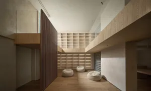 A minimalist library with wooden shelves and seats.