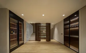 A modern wine cellar with dark wood, glass, and concrete elements.