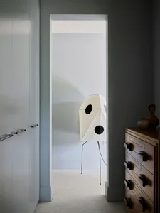 A minimalist interior space featuring a fabric screen with black circles.