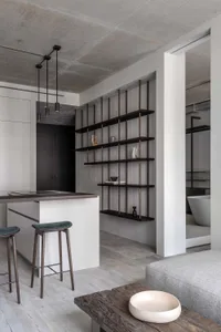 Modern kitchen featuring minimalist design with concrete, wood, and metal elements.