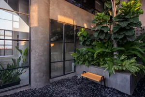 A minimalist garden with concrete and glass planters, showing a modern industrial design style.