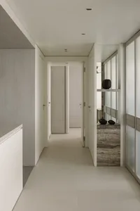 Modern minimalist hallway with neutral tones and wood details.