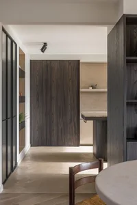 A photograph of a modern residential kitchen featuring a concrete floor and minimalist design elements.