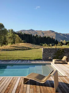 A modern residential patio featuring wood, stone, and metal elements.