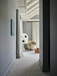 Modern living room with curtains, minimalist furniture, and neutral color palette.