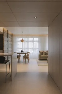 A modern living room with neutral-toned furniture and a large window.