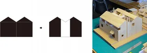 A wooden architectural model of a house on a green cutting board.
