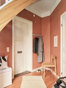 Clothing hanging space featuring wooden floors and a concrete door with a wooden frame.
