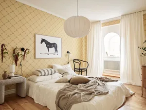 Minimalist bedroom with white walls, bed, and fabric coverings.