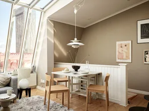 Minimalist living room with modern furniture, wood floor, and floor-to-ceiling windows.