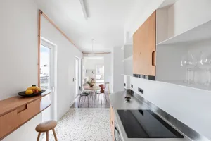 A modern kitchen with a white and brown terrazzo floor and minimalist design.