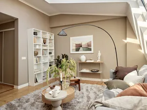 Minimalist living room with concrete and wooden elements, round table, white shelves, and floor lamp.