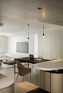 簡約住宅室內空間，採用大理石與木質材料，搭配黑色餐桌與大型電視螢幕