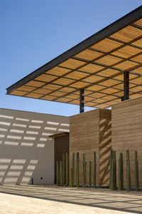 A modern architectural design featuring a wooden roof structure and concrete walls.