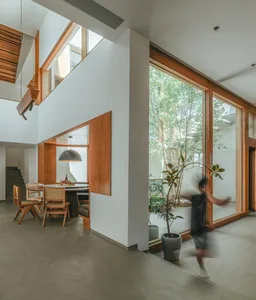 A modern living room featuring concrete, glass, and wooden elements.