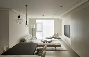 A modern living room with neutral-colored furniture, a large window, and minimalist decor.